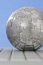 Metal puzzle globe on computer keyboard Royalty Free Stock Photo