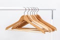 Metal rack with wooden clothes hangers on white background Royalty Free Stock Photo