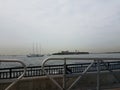 Metal railing and fence and boat and liberty island