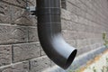 Metal rain gutter downspout pipe with anchor bolt holder on the house brick wall Royalty Free Stock Photo