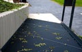 Metal ramp for wheelchairs made of dark gray lattice and retaining wall at the flowerbed made of prefabricated concrete palisade o Royalty Free Stock Photo