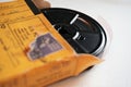 Home movie filmstrip reel peeks from yellow box