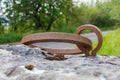 Metal ring and eye fixed to a large heavy bolder rock climbing anchor point Royalty Free Stock Photo