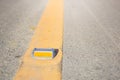 Metal road stud with yellow line on the road Royalty Free Stock Photo