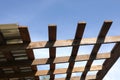 Metal roof mounting on brown wooden gazebo crate on a sunny summer day bottom up view outdoor