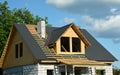 Metal roofing construction. Metal roof tiles installation on a gable roof with attic windows and chimney of a house under Royalty Free Stock Photo