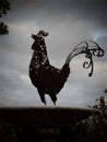 Metal rooster on top of a bird bath