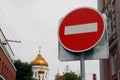 Metal round red road stop sign with white stripe in the background of golden dome of orthodox church