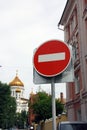 Metal round red road stop sign with white stripe in the background of golden dome of orthodox church