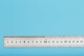A metal ruler with a scale on a blue background is a superscape with a copy of the space for your text