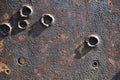 A metal rusty plate of the armor of an old mortar with traces and bullet holes.