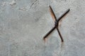 Metal rusty rods in the form of a cross on a concrete wall Royalty Free Stock Photo