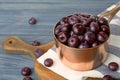 Metal saucepan of fresh acai berries on blue wooden table Royalty Free Stock Photo