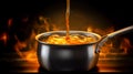 Metal saucepan with hot liquid on table against dark background. Royalty Free Stock Photo