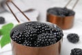 Metal saucepan with tasty ripe blackberries on table, Royalty Free Stock Photo
