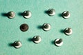 Metal screws on green craft paper with shadow