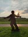 Metal sculpture: a boy on a skateboard. Monument to the athlete against the backdrop of the sunny sky. Silhouette of an athlete