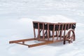 Metal sculpture of a carriage covered with snow and stands in the middle of a snowy field, winter background Royalty Free Stock Photo