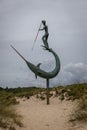 Metal sculpture of a harpooner on the beach