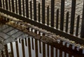Metal security fencing reflected in a rain water puddle