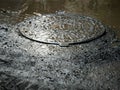 Metal sewage cover in the flooded city,