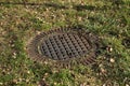 A metal sewer hatch in the grass Royalty Free Stock Photo