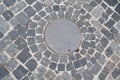 Metal sewer hatch on the stone pavement Royalty Free Stock Photo