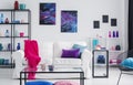 Metal shelves with vases behind white couch with pink blanket and purple and blue pillows, real photo Royalty Free Stock Photo