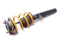 Metal shock absorber for car suspension in black with a yellow spring on a white isolated background in a photo studio in a Royalty Free Stock Photo