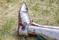 Metal shoes of a knight on the grass in nature