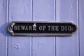 Metal sign Beware of the dog attached to a light blue wooden gate Royalty Free Stock Photo