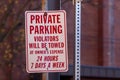 A metal sign at a parking lot that says ` Private Parking, violators will be towed at owner`s expense