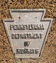 A metal sign in the shape of a keystone with Pennsylvania Department of Highways on it