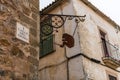Metal silhouette of a seated monkey hanging from the corner of Calle del Mono in the Old Town of Caceres.