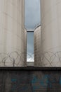 Metal silo, store behind a concrete wall with barbed wire