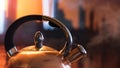 A metal silver teapot on a gas stove in the kitchen at home. Concept. Close up of steel kettle with boiling water Royalty Free Stock Photo