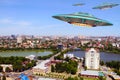 A metal and silver UFO invasion of planet Earth, a group of spaceships fly in the sky above the city and emit yellow rays to the Royalty Free Stock Photo