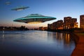 A metal and silver UFO invasion of planet Earth, a group of spaceships fly in the sky above the city and emit yellow rays to the Royalty Free Stock Photo