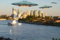 A metal and silver UFO invasion of planet Earth, a group of spaceships fly in the sky above the city and emit yellow rays to the Royalty Free Stock Photo