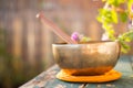 Singing bowl on a rustic wooden table with flowers, zen, outdoors Royalty Free Stock Photo