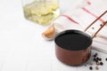 Metal small saucepan with balsamic vinegar and ingredients on white tiled table. Space for text Royalty Free Stock Photo