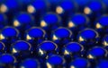 Metal small sphere shined with blue and gold light. Macro photo, abstract background