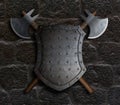 Metal spiked shield and two crossed battle axes on stone wall 3d illustration Royalty Free Stock Photo