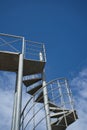 Metal spiral staircase on a blue sky background Royalty Free Stock Photo