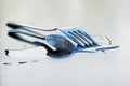 Metal spoon and fork on a large water drop on a clean surface Royalty Free Stock Photo