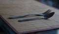 Spoon and fork lying on a bamboo mat