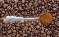 Metal spoon with ground coffee on table with coffee beans Royalty Free Stock Photo