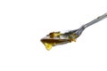 Metal spoon with a pouring drop of golden honey Royalty Free Stock Photo