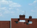 Metal stacks and chimneys on brown clay or concrete tile roof