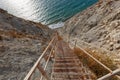 A metal staircase leading down to the rugged, unspoilt coastline of the sea. Royalty Free Stock Photo